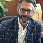Portrait photo of Shawn Mahoney in a blue checked suit